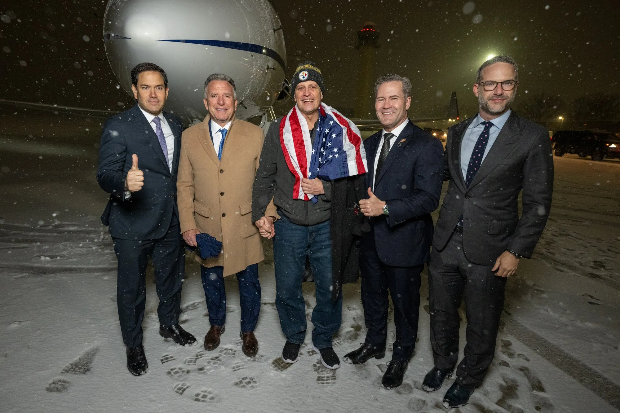 Marc Fogel after his return to the United States, Joint Base Andrews, 11 February 2025, with Marco Rubio, Steve Witkoff, Mike Waltz and Adam Boehler. Photo: The White House / Jherbert3 (resized). Licence: CC BY-SA 4.0. Source: Wikimedia Commons
